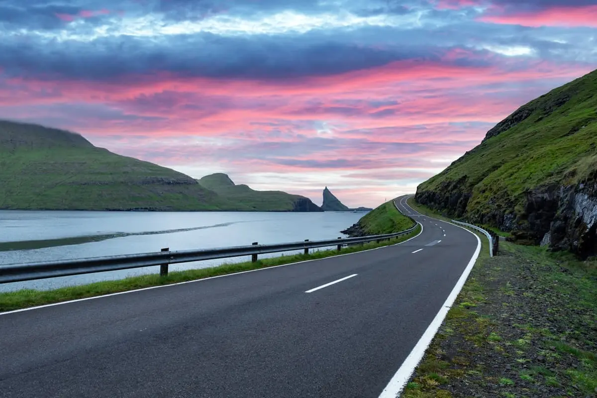 Scenic Sørvágur to Gásadalur scooter ride with Tindhólmur in the distance under a red sky